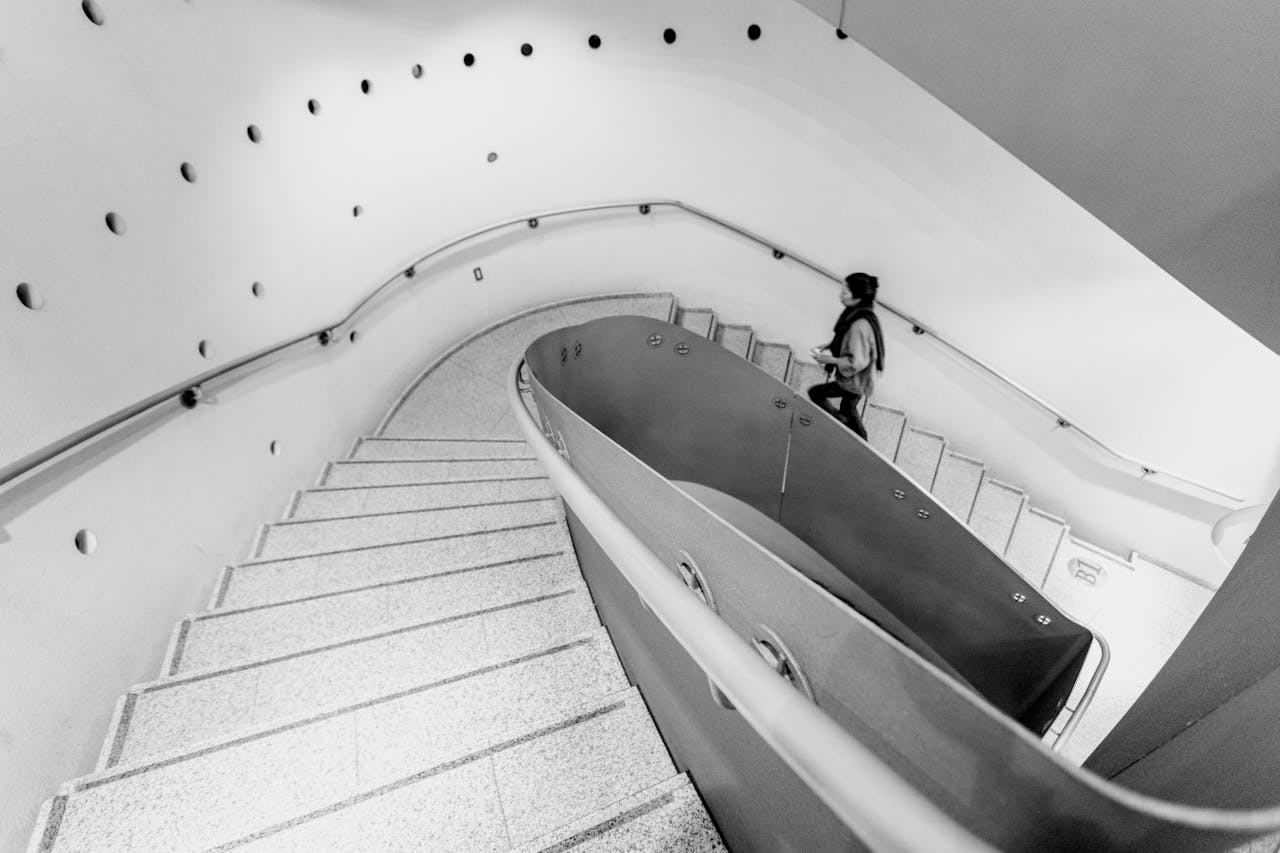 A striking black and white view of a spiral staircase in Taito City, Tokyo with contemporary architectural design.
